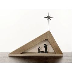 a nativity scene in a wooden frame with a star on the top and two figurines