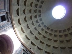 looking up at the ceiling and dome of an ancient building with light coming through it