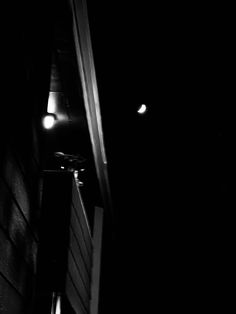 a black and white photo of a street light in the dark with only one light on