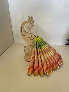 a group of multicolored paper straws sitting on top of a table next to a wooden sign