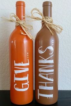 two orange and brown wine bottles sitting on top of a table