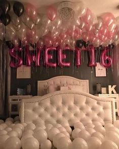 balloons are floating in the air above a bed with a white headboard and foot board