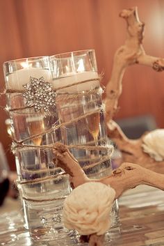 some candles are sitting on a table with driftwood