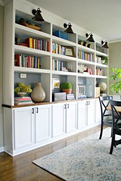 a dining room table with chairs and bookshelves