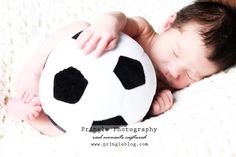 a baby is sleeping with a soccer ball