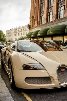 a bugatti is parked on the side of the road in front of a building