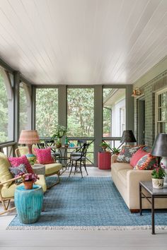 a living room filled with lots of furniture and decor on top of a blue rug