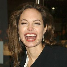 a woman laughing with her eyes closed