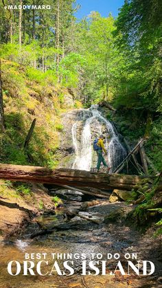 a man standing on top of a bridge next to a waterfall