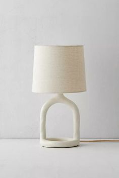 a white table lamp with a beige shade on it