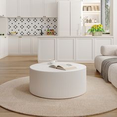 a white living room with a round coffee table