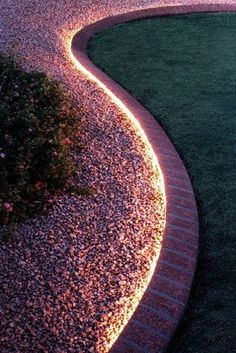 a garden path lit up with lights and gravel