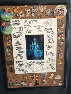 a photo frame with many disney world pins and magnets on it