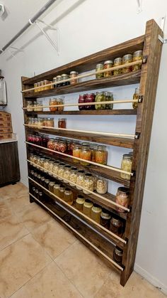 a wooden shelf filled with lots of different types of food in jars and jars on top of each shelf