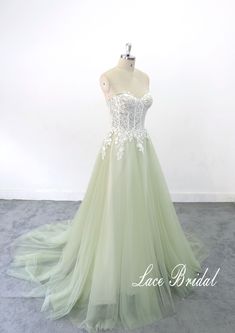 a green and white wedding dress on a mannequin