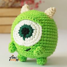 a green crocheted toy with an eyeball on it's face and horns