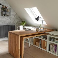 an attic office with a desk and bookshelf