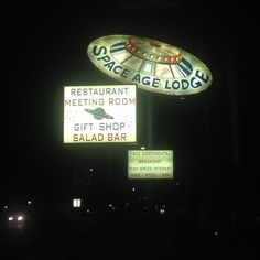 a neon sign that says space age lodge and the restaurant meeting room gift shop salad bar