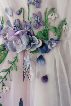 a dress with flowers and leaves on the front is made up of tulle fabric