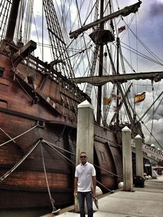 a man standing in front of an old ship