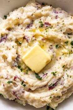 mashed potatoes with butter and parsley in a white bowl