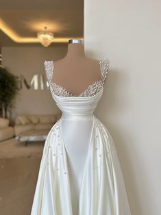 a white wedding dress on display in a room