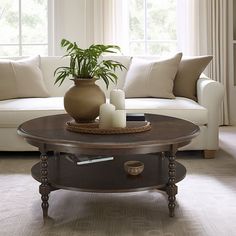 a living room with a couch, coffee table and potted plant on top of it