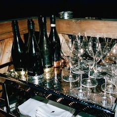 many wine glasses and bottles on a table