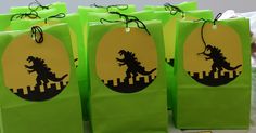 green bags with black silhouettes of dinosaurs on them and yellow tags hanging from the handles