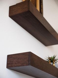 two wooden shelves are hanging on the wall