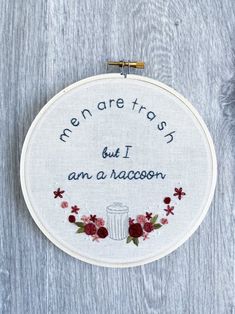 a white embroidered hoop with words on it that says men are tasty but i am a racoon