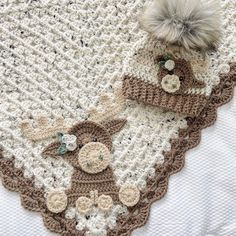 there is a crocheted blanket with two hats on it and a pom - pom