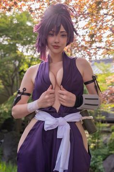 a woman with purple hair is posing for the camera and holding her hands on her chest