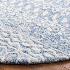 a blue and white rug on the floor with wood floors in front of it,