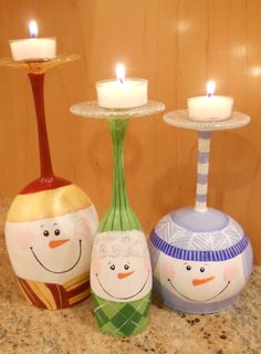 three decorated vases sitting on top of a counter with lit candles in the background