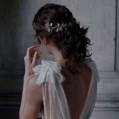 a woman wearing a white dress with a flower in her hair