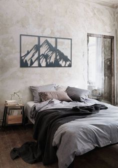 a bed sitting in a bedroom next to two framed pictures on the wall above it