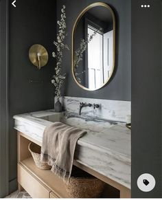 a bathroom with marble counter top and gold mirror