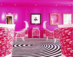 a room with pink walls and white chairs