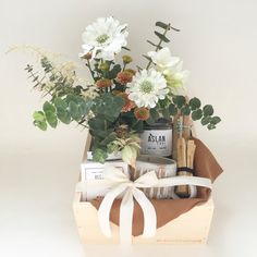 a wooden box filled with lots of different types of items and flowers on top of a table