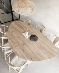 a wooden table surrounded by white chairs