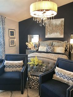 a bed room with a neatly made bed and two blue chairs next to each other