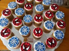 cupcakes decorated with spider - man icing on a plate