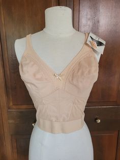 This is a very cool vintage new old stock piece in perfect condition with tags in tact. This is a lovely long line shapewear bra that will give your bust a lift, smooth out your back with no pressure from a strap, and sinch in your waist for an hourglass silhouette. This piece features boning at the back and front sides to to add to that contoured appearance. These cups are a full coverage style with wider straps. It is decorated with a little satin bow at the front and scalloped lacing throughout. The back fastening have two rows of hooks to close with a row of eyes. Measurements: (inches/flat) Measured on tightest setting, a couple inches of room with adjustments and stretch. 36D Waist- 13.5 Condition: Perfect new old stock Shapewear Bra, Bra Items, Hourglass Silhouette, Longline Bra, Soft Cup, Satin Bow, Cool Vintage, Scalloped Lace, Satin Bows