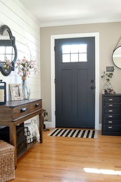 a room with a black door and some drawers on the side walk in front of it