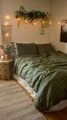 a bed with green comforter and pillows in a room decorated with plants on the wall