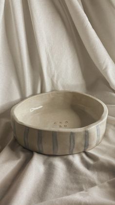 a white bowl sitting on top of a bed