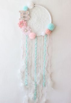 a white dream catcher hanging on the wall