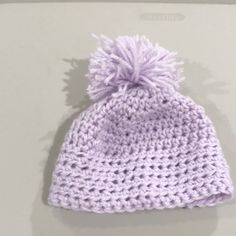 a crocheted beanie with a pom - pom on the top