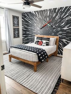 a bedroom with a black and white wallpaper behind the bed is decorated in modern style